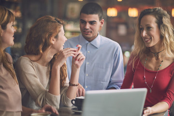 Four friend in the cafe, watching laptop