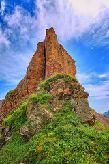 Fototapeta na wymiar Pointed steep red rock on watershed ridge