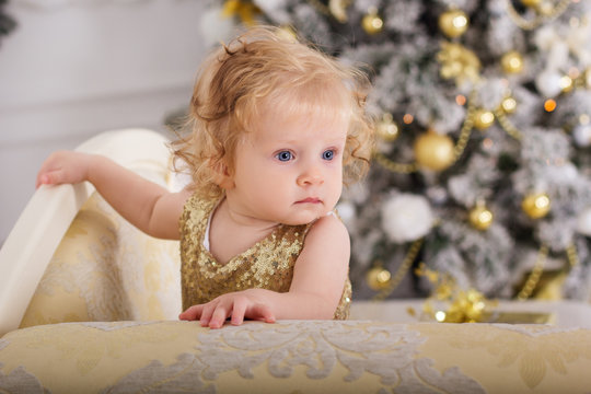 Baby girl near luxury decorated christmas tree