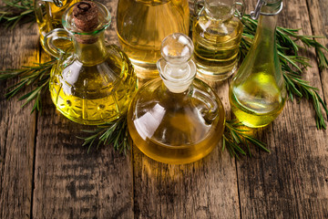 Assortment of spicy sunflower,corn,sesame seeds ,avocado ,grape seeds oils with herbs and spices in different bottles on wooden background