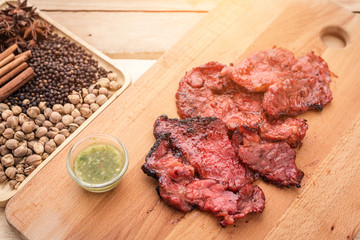 grilled meat, sprig of rosemary and red hot pepper on a wooden l