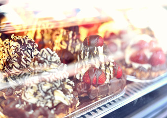 Delicious sweet waffles with cream and fresh fruits behind a shop window.