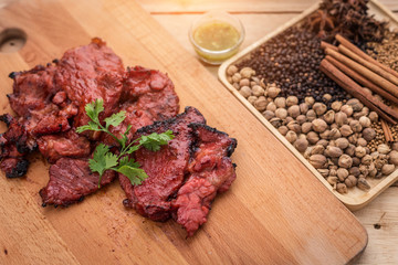 grilled meat, sprig of rosemary and red hot pepper on a wooden l