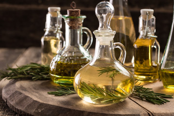 Assortment of spicy sunflower,corn,sesame seeds ,avocado ,grape seeds oils with herbs and spices in different bottles on wooden background