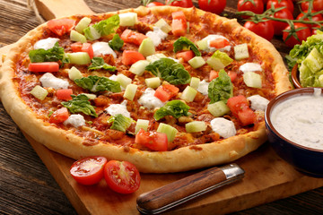 Fresh homemade pizza with chicken and garlic sauce on wooden bac