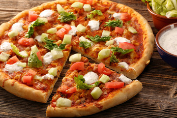 Fresh homemade pizza with chicken and garlic sauce on wooden bac