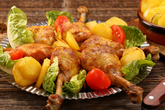 Chicken legs and baked potatoes with vegetable