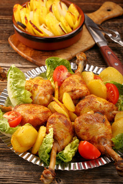 Chicken legs and baked potatoes with vegetable