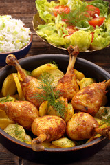 Chicken legs and baked dill potatoes with vegetable salad