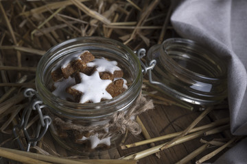 Glass jar with cookies Christmas star on a background of hay.