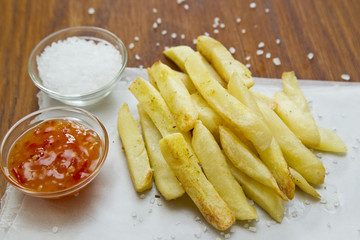 Tasty baked French fries on grease proof paper