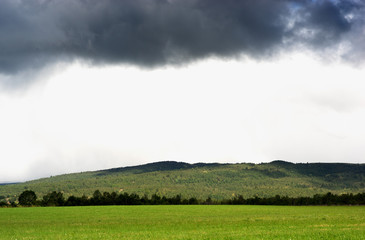 Naklejka na ściany i meble Horizontal Norway field under overcast clouds background