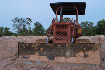 Old Crawler Dozer detail - Old Red Tractor on construction site of repair and expansion of the yard and suburban home


