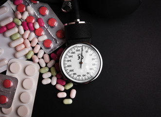 Blood pressure meter and stethoscope, on dark wooden background