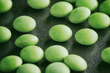 Green Tablets Or Drugs Circular Shape On A Black Background. Vintage, Grunge Version.