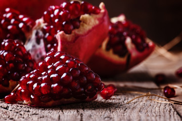 Pieces of pomegranate, rustic style, old wooden background, sele