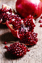 Pieces of pomegranate, rustic style, old wooden background, sele