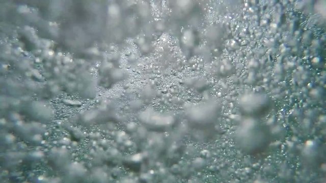 Man drowning in deep sea water, hand asking for help sticking out toward the sun from cold water with air bubbles, pov shot
