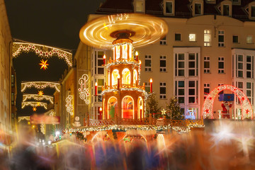 Decorated and illuminated Christmas street with carousel at night in Dresden, Saxony, Germany