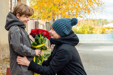 Boy gives mom a bouquet of roses