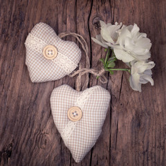Fabric retro hearts with white spring flowers  on an old vintage wood