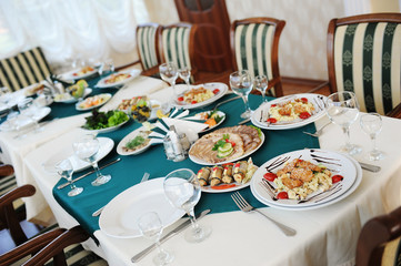 Set the table in the restaurant. Bright interior. Salads and snacks