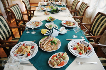 Set the table in the restaurant. Bright interior. Salads and snacks