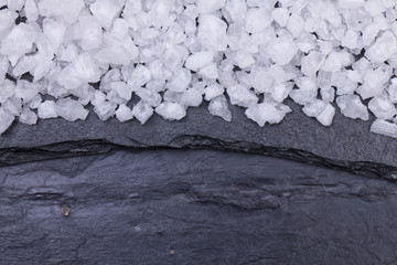 Sea salt on a black grungy stone surface