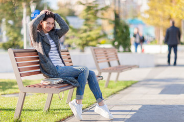 Beautiful stylish woman in blue jeans, trendy shoes and cozy tre