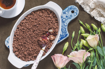 Chocolate crumble with pears and plums and a bunch of flowers