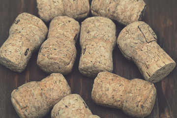 corks from bottles of champagne closeup on wooden background, vintage processing