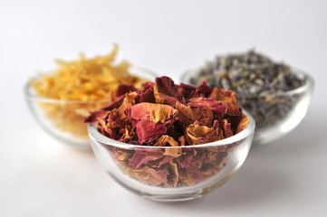 Dried flowers of marigold (calendula), lavender and rose for beauty treatments in clear glass bowls 