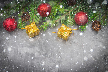 Fototapeta na wymiar Christmas tree branch with a toy on a gray background