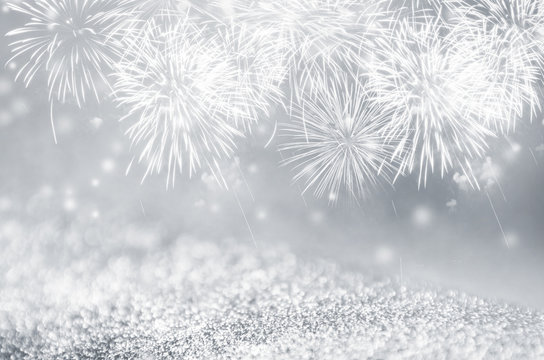 Defocused silver and gray fireworks and bokeh on gliter paper at New Year and copy space. Abstract background holiday.