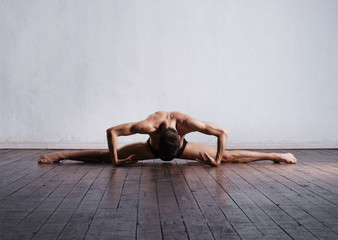Handsome ballet dancer sitting on splits