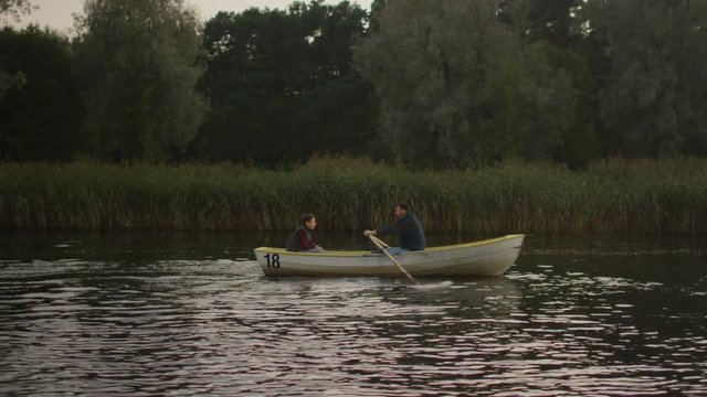 Father and Son on the Boat. Father Rows the Boat. Shot on RED Cinema Camera in 4K (UHD).