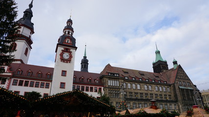Auf dem Weihnachtsmarkt in Chemnitz/Auf dem Weihnachtsmarkt in Chemnitz in Sachsen, Deutschland; illumierte Buden, das Alte und Neue Rathaus, im Hintergrund der Turm der Jakobikirche
