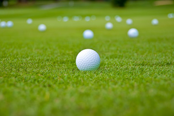 Pitching and chipping areas over a sand bunker. Shallow depth of field. Focus on the closest ball.