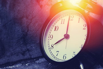 Obraz na płótnie Canvas 8 o'clock vintage clock at dark color tone with sun light memory time concept.