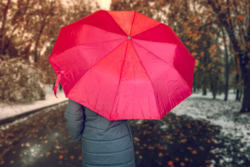 Portrait of  woman with .purple umbrella - view with back standing over  background of  just came winter