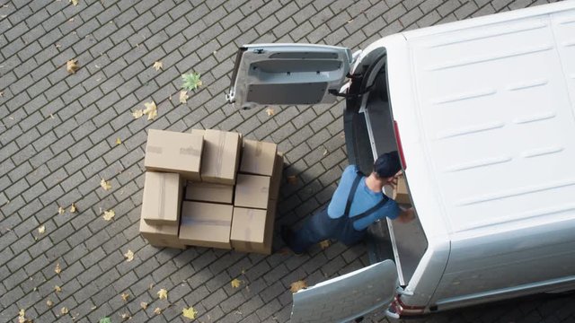 Delivery Man Loads his Commercial Van with Cardboard Boxes. Shot on RED Cinema Camera in 4K (UHD).