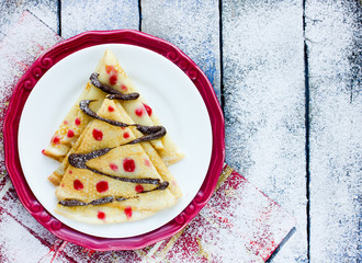 Delicious breakfast crepes shaped Christmas tree with chocolate