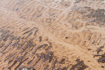 Wavy sand with silt on the beach after the low tide