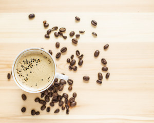 Appetizing cup of coffee and grain lying on the wooden table