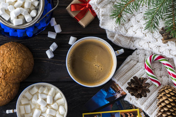 cup of coffee with marshmallows, knitted sweater and christmas decoration