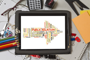 Public Relation word cloud shaped as a arrow to the right on a tablet screen