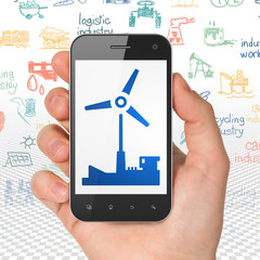 Industry concept: Hand Holding Smartphone with Windmill on display