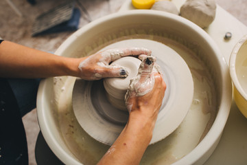 Fototapeta premium Hands working on pottery wheel