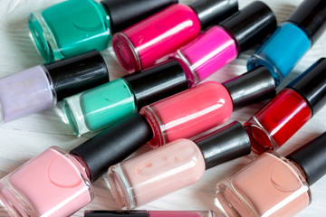 bottles of colored nail polish on wooden background