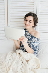 Girl looking at tablet in bed